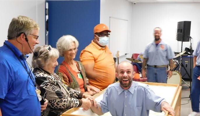 Man smiling as he is baptized at St Brides Correctional center